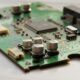 Detailed view of a green circuit board featuring capacitors and microchips.
